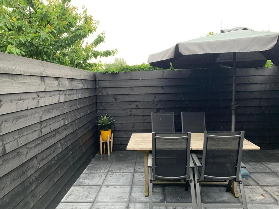 Beschut terras met tuintafel en parasol