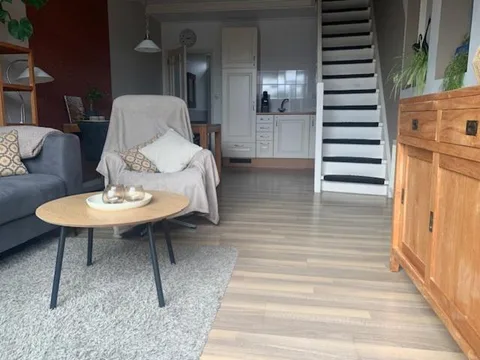 Lichte woonkamer met zithoek en trap